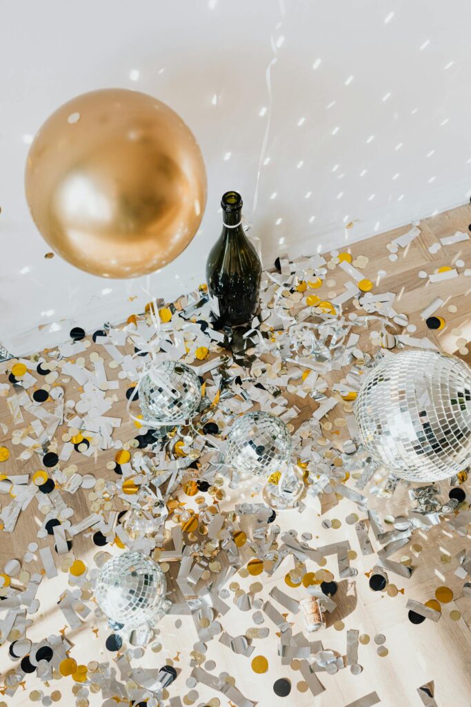 Celebratory scene with confetti, disco balls, and a bottle, perfect for events and parties.